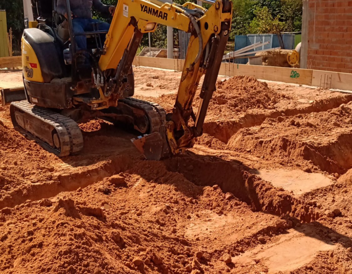 Miniescavadeira abrindo valas de fundação